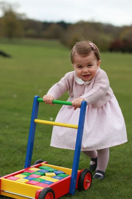 Princess Charlotte pushing a childrens toy.